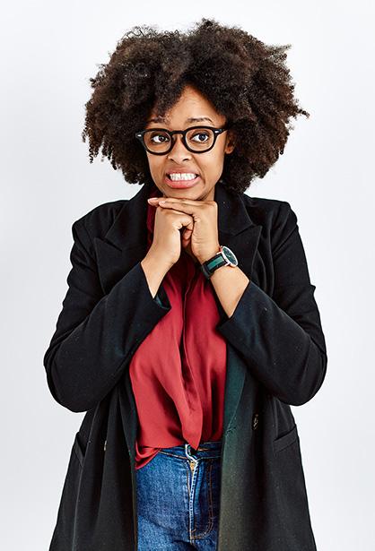 A woman wearing glasses with an awkward expression and her arms.